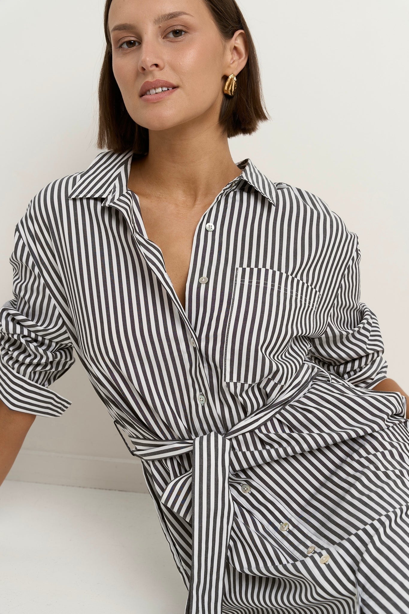 Say yes to timeless stripes with a modern twist, the Forward Black Stripe Shirt Dress blends structure and ease in all the right ways. With its flattering tie waist, crisp collar, and functional pockets, this dress does it all without ever feeling fussy. Throw it on and go, or style it up with your favourite accessories. A true high-low hero, equally perfect for desk days, market strolls or casual catch-ups.

- Classic black and white vertical stripe
- Button-down front with shirt collar
- Removable waist t